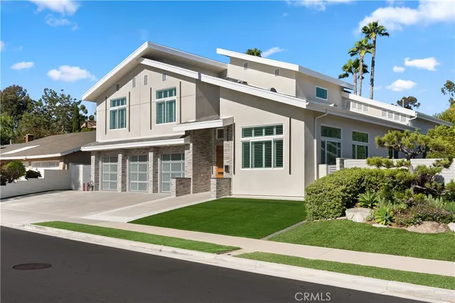 a front view of a house with a yard and potted plants