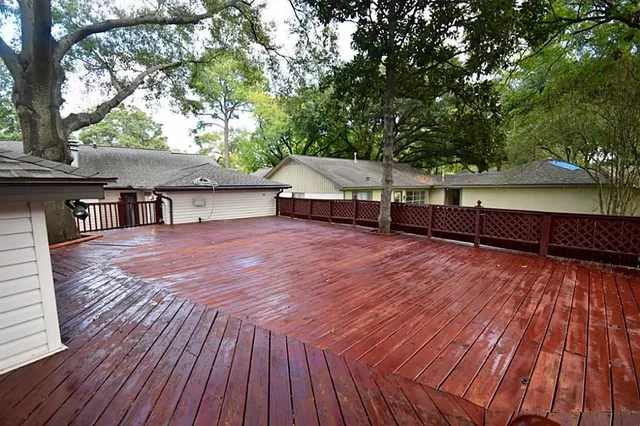 a view of a house with wooden deck and trees
