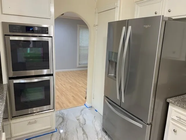 a metallic refrigerator freezer sitting in a kitchen