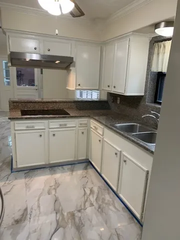 a kitchen with granite countertop a sink and cabinets
