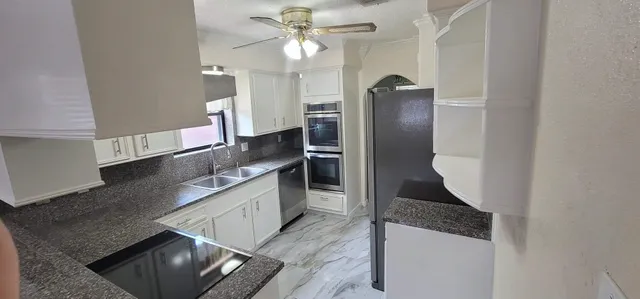 a kitchen with stainless steel appliances granite countertop a sink and a stove