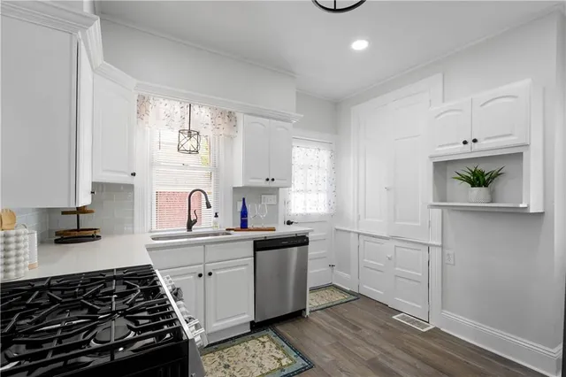 a kitchen with white cabinets and appliances