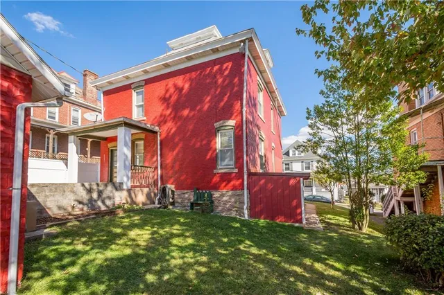 a view of a house with a yard and wooden fence