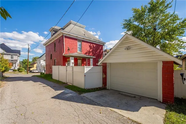 an aerial view of residential houses with outdoor space and trees