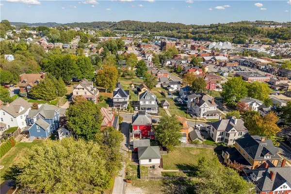 an aerial view of residential houses with outdoor space and trees