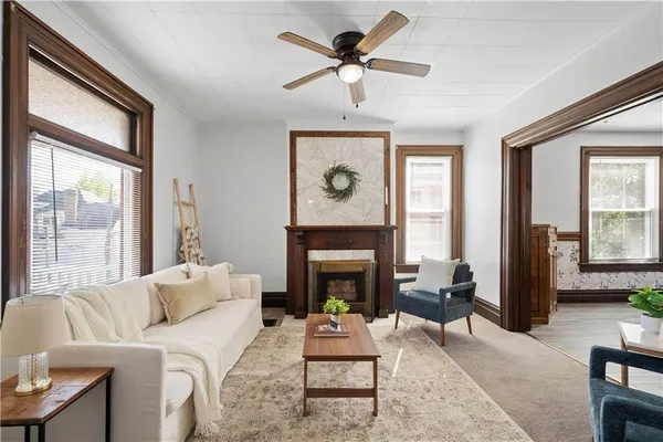 a living room with furniture a fireplace and a large window