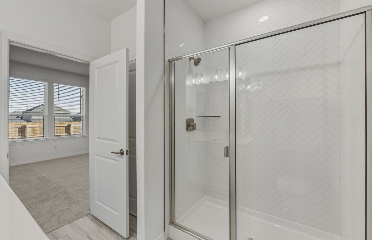 472 Tailwind Drive Kyle, TX 78640 - Photo 11 of 22 a bathroom with a glass shower door