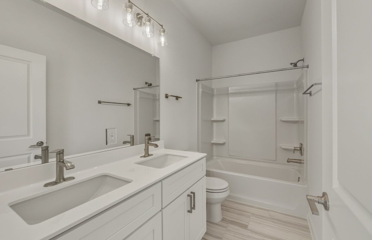 472 Tailwind Drive Kyle, TX 78640 - Photo 16 of 22 a bathroom with a granite countertop sink a toilet and shower