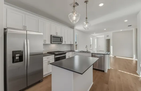 a kitchen with stainless steel appliances kitchen island granite countertop a sink and cabinets