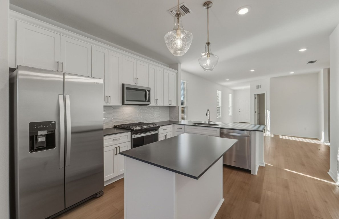 472 Tailwind Drive Kyle, TX 78640 - Photo 3 of 22 a kitchen with stainless steel appliances granite countertop a refrigerator a sink and a stove