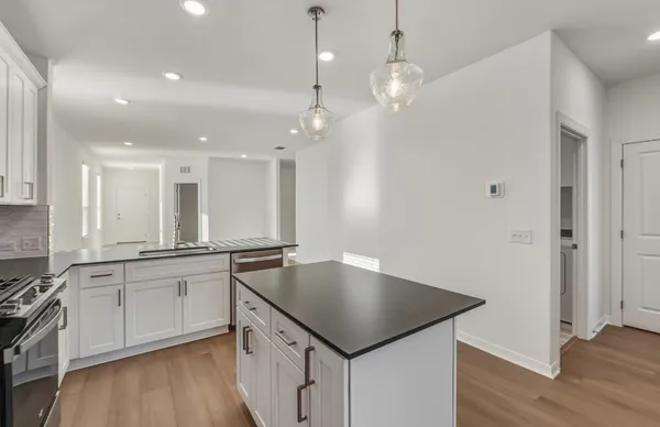 a kitchen with stainless steel appliances granite countertop a refrigerator a sink and a stove