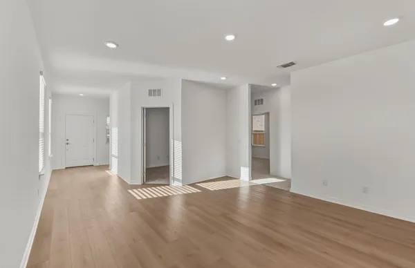 a view of a big room with wooden floor and windows