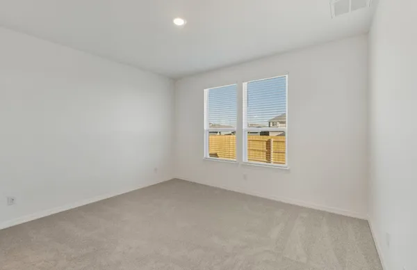 an empty room with wooden floor & windows and bathroom