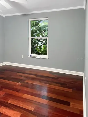 a view of a room with wooden floor and a window