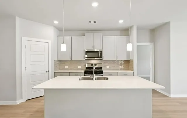 a kitchen with a stove a sink and a refrigerator