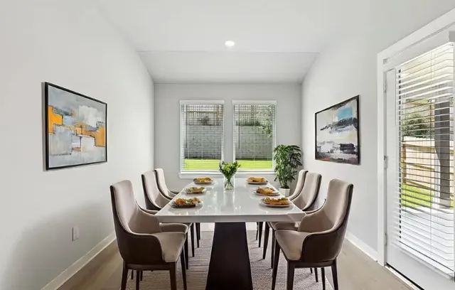 a view of a dining room with furniture a large window and garden