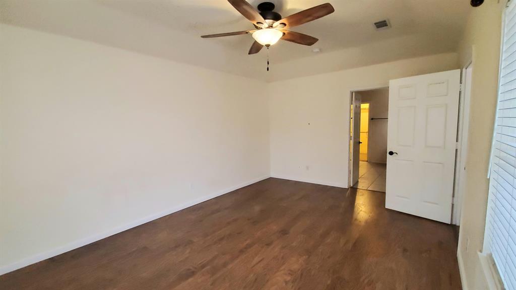 8017 Clipper Street Frisco, TX 75035 - Photo 15 of 21 an empty room with wooden floor a ceiling fan and closet