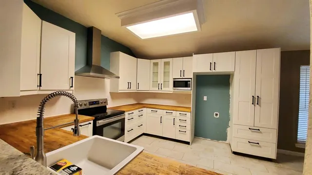 a kitchen with stainless steel appliances kitchen island granite countertop a refrigerator and cabinets