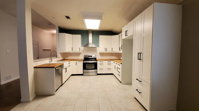 a kitchen with stainless steel appliances a refrigerator sink and cabinets