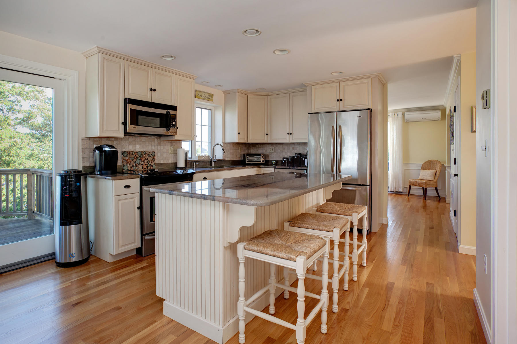 62 Long Beach Road Centerville, MA 02632 - Photo 7 of 27 a kitchen with stainless steel appliances granite countertop a refrigerator a stove top oven a sink dishwasher and white cabinets with wooden floor