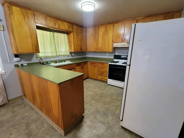 a kitchen with stainless steel appliances granite countertop a stove a sink and a refrigerator