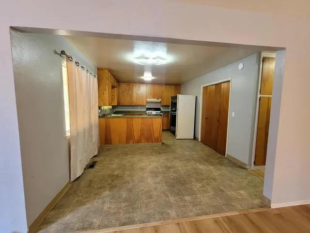 a view of a refrigerator in kitchen and a window