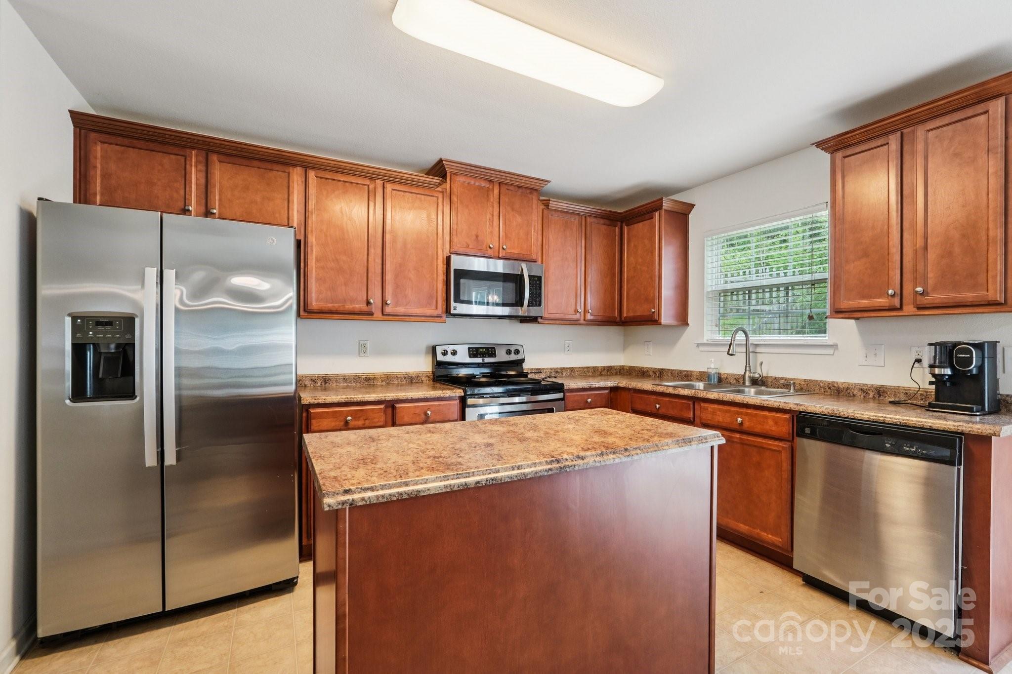2289 Reid Pointe Avenue Indian Land, SC 29707 - Photo 11 of 39 a kitchen with a refrigerator a microwave a sink and cabinets