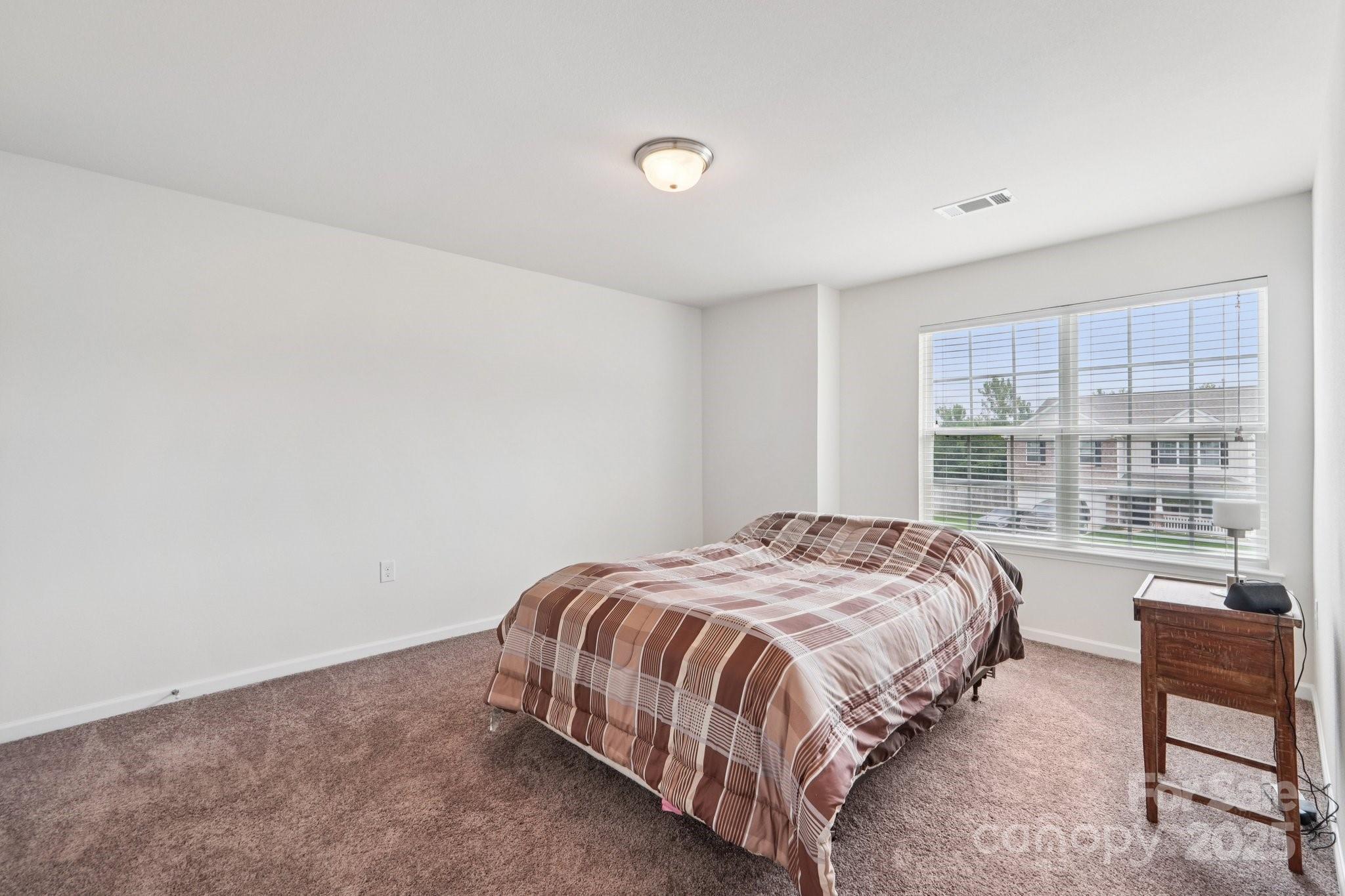 2289 Reid Pointe Avenue Indian Land, SC 29707 - Photo 31 of 39 a bed sitting in a bedroom next to a window