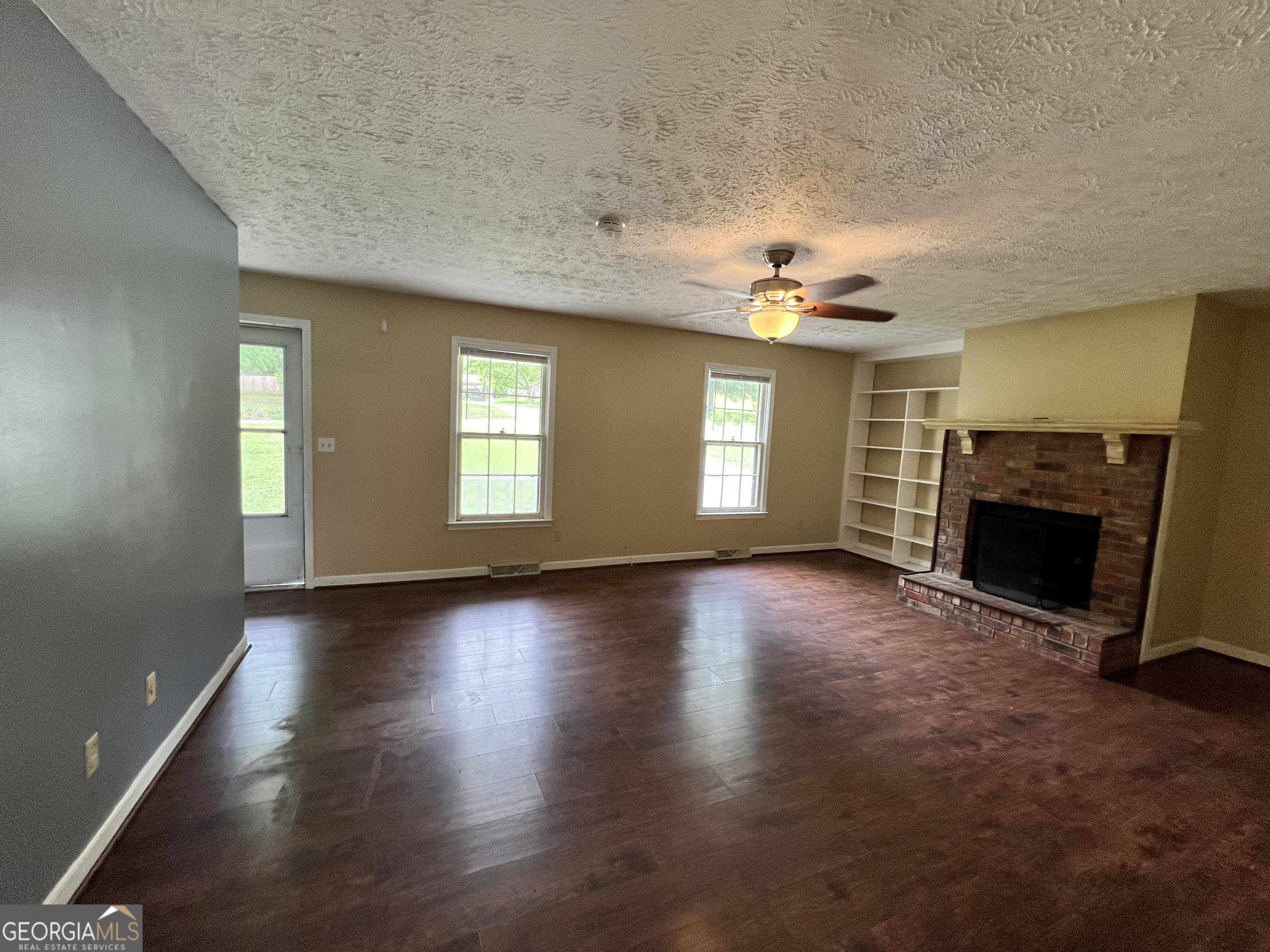 32 Ford Drive Southeast Rome, GA 30161 - Photo 6 of 49 an empty room with windows fireplace and a kitchen view