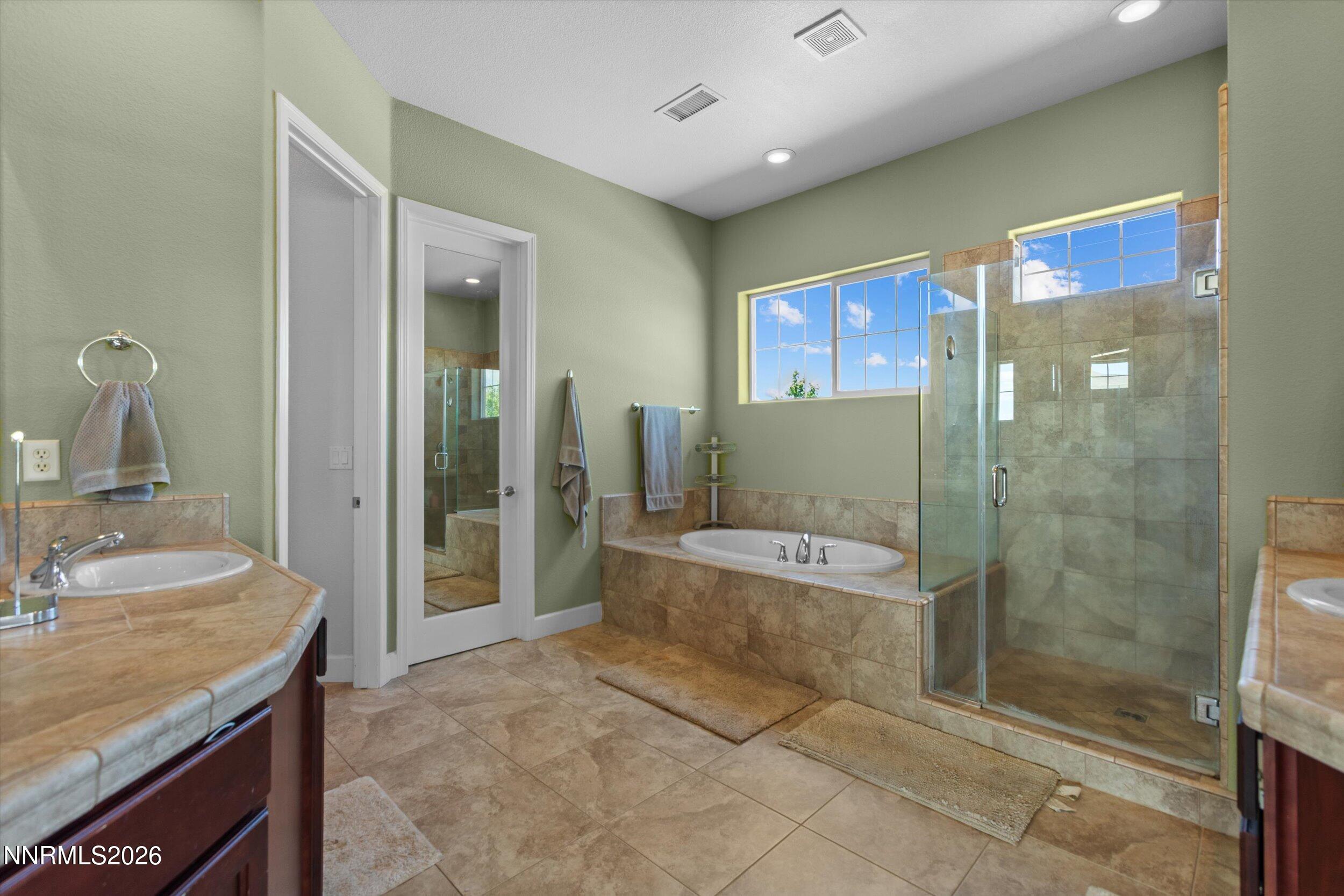 2920 Bull Rider Drive Reno, NV 89521 - Photo 35 of 51 a bathroom with a granite countertop sink a toilet a mirror and shower