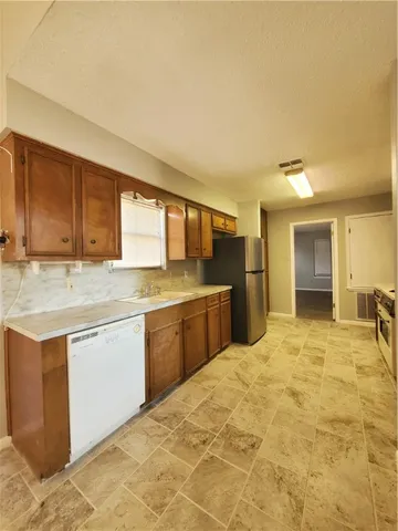 a large kitchen with stainless steel appliances granite countertop a sink and cabinets