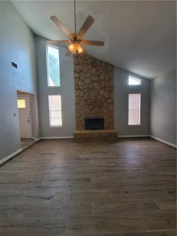 an empty room with windows and fireplace