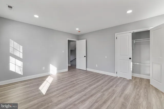 a view of empty room with wooden floor and window