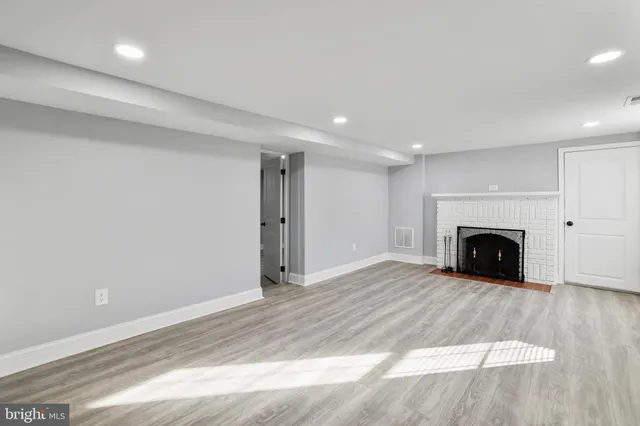 a view of an empty room with a fireplace and a window