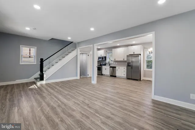 a view of a livingroom with wooden floor and staircase