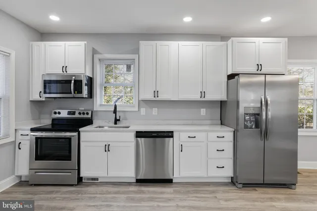 a kitchen with stainless steel appliances granite countertop a stove a sink and a refrigerator