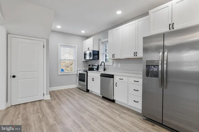 a kitchen with white cabinets and stainless steel appliances