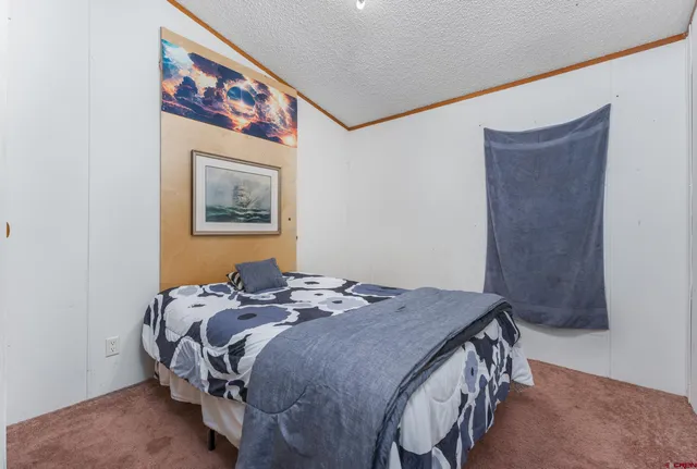 a bedroom with a bed and a painting on the wall