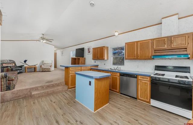 a kitchen with stainless steel appliances a stove a sink dishwasher and cabinets with wooden floor