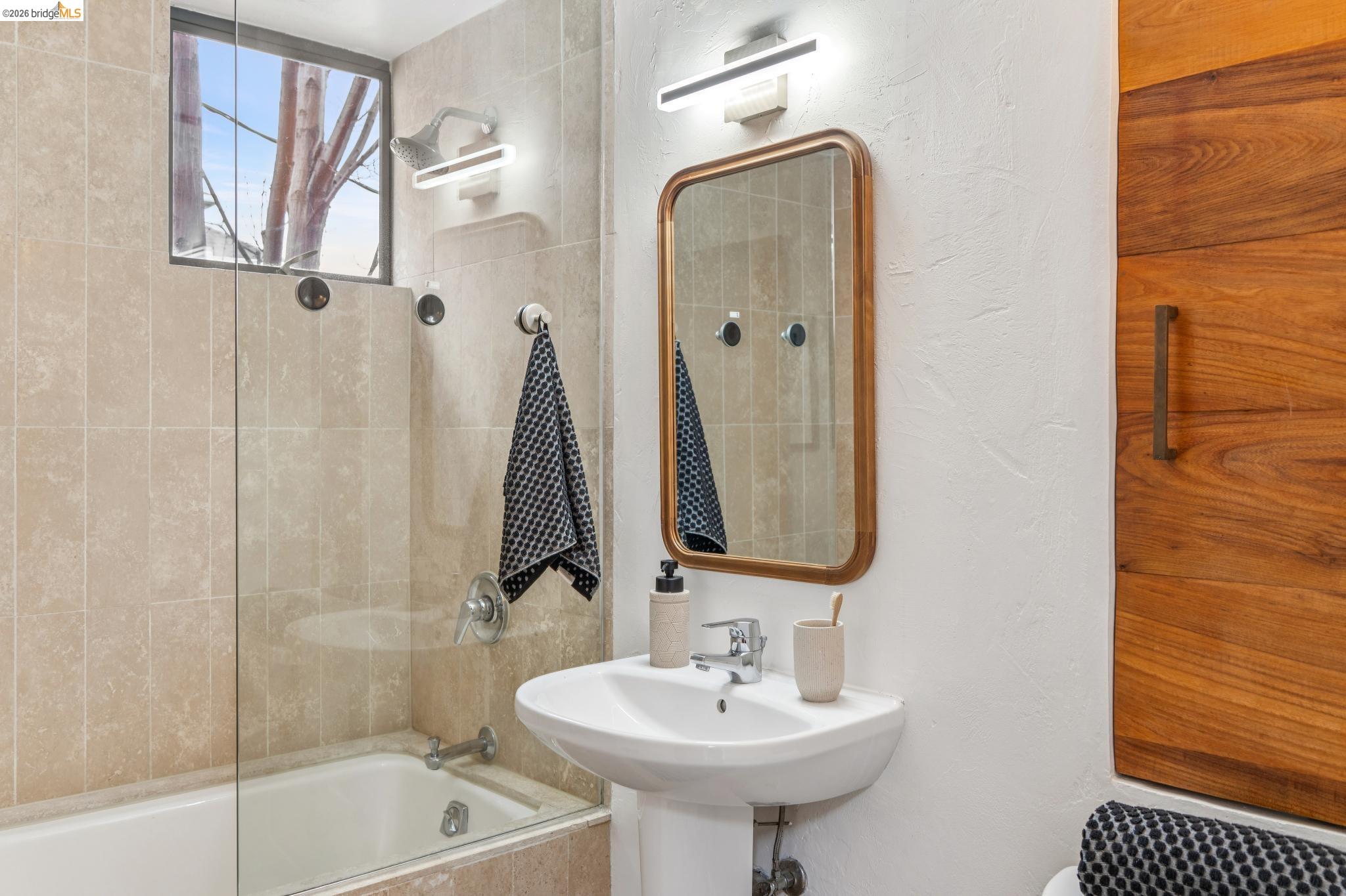 2015 Delaware Street, Unit A Berkeley, CA 94709 - Photo 43 of 60 a bathroom with a sink a mirror and a bathtub