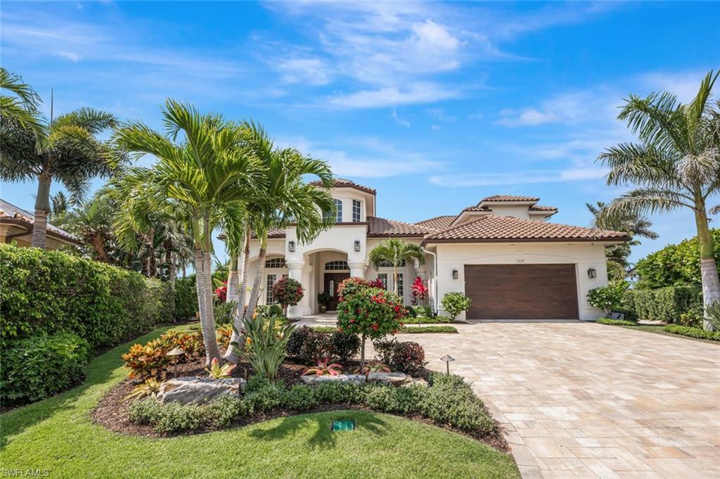 4129 Willowhead Way Naples, FL 34103 - Photo 1 of 50 a front view of a house with a yard garage and outdoor seating