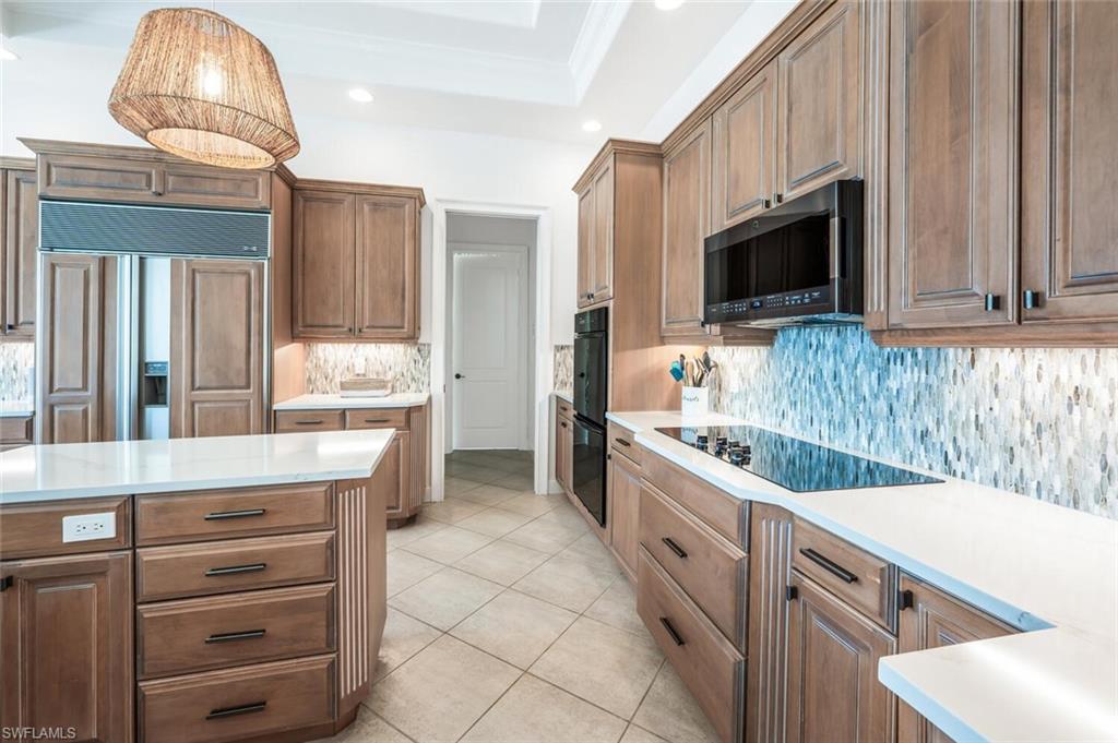 4129 Willowhead Way Naples, FL 34103 - Photo 11 of 50 a kitchen with granite countertop a sink and a stove top oven
