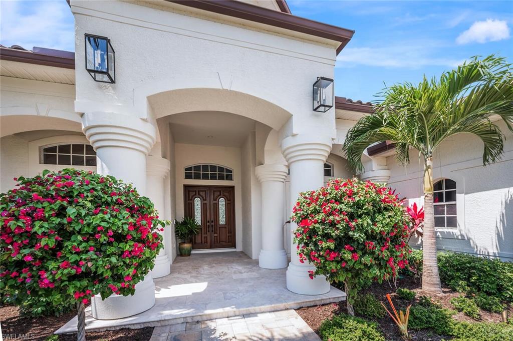 4129 Willowhead Way Naples, FL 34103 - Photo 2 of 50 a front view of a house with a flower garden