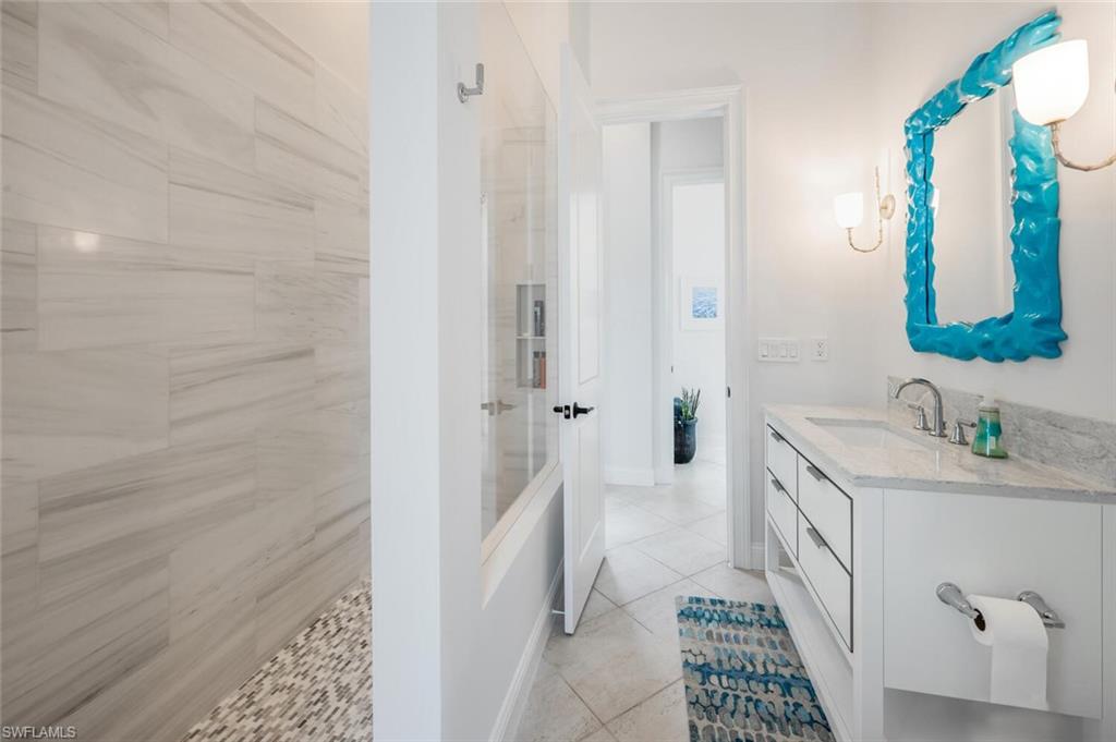 4129 Willowhead Way Naples, FL 34103 - Photo 26 of 50 a bathroom with a sink a mirror and a shower
