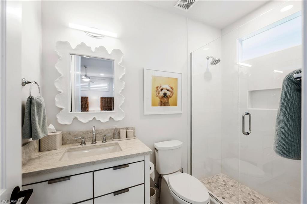 4129 Willowhead Way Naples, FL 34103 - Photo 31 of 50 a bathroom with a toilet sink vanity granite and shower