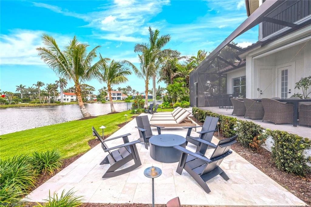 4129 Willowhead Way Naples, FL 34103 - Photo 50 of 50 a view of a patio with table and chairs potted plants and palm tree