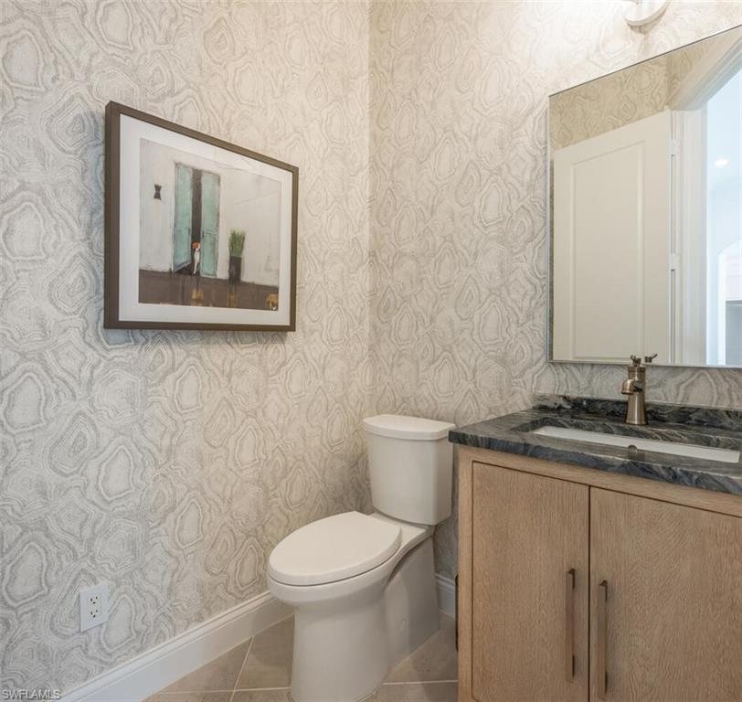4129 Willowhead Way Naples, FL 34103 - Photo 8 of 50 a bathroom with a granite countertop toilet a sink and mirror