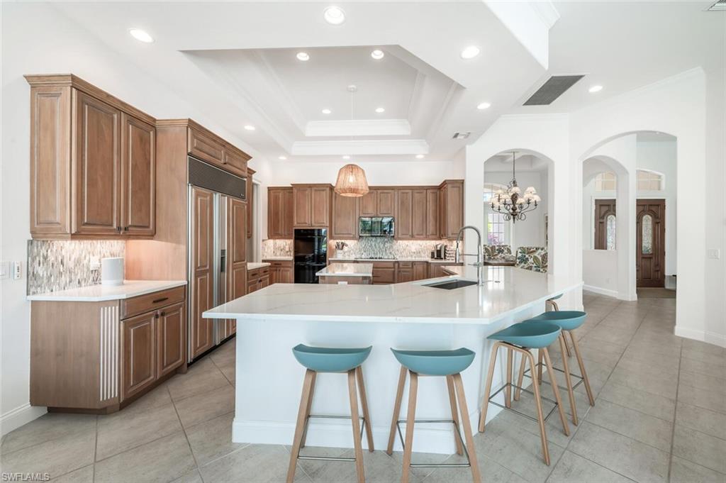 4129 Willowhead Way Naples, FL 34103 - Photo 10 of 50 a kitchen with stainless steel appliances kitchen island granite countertop a table and chairs