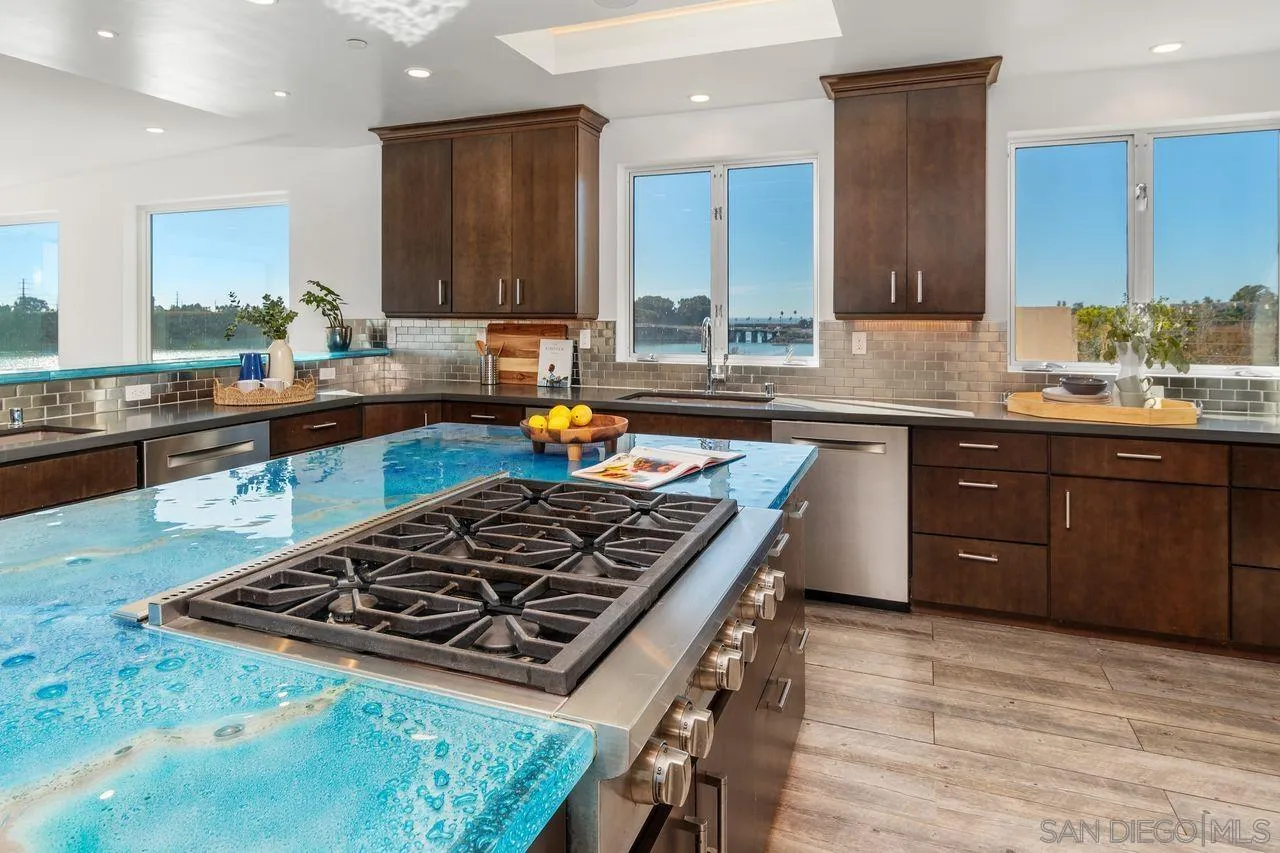 4465 Adams Street Carlsbad, CA 92008 - Photo 26 of 59 a kitchen with stainless steel appliances granite countertop a stove a sink dishwasher and cabinets with wooden floor
