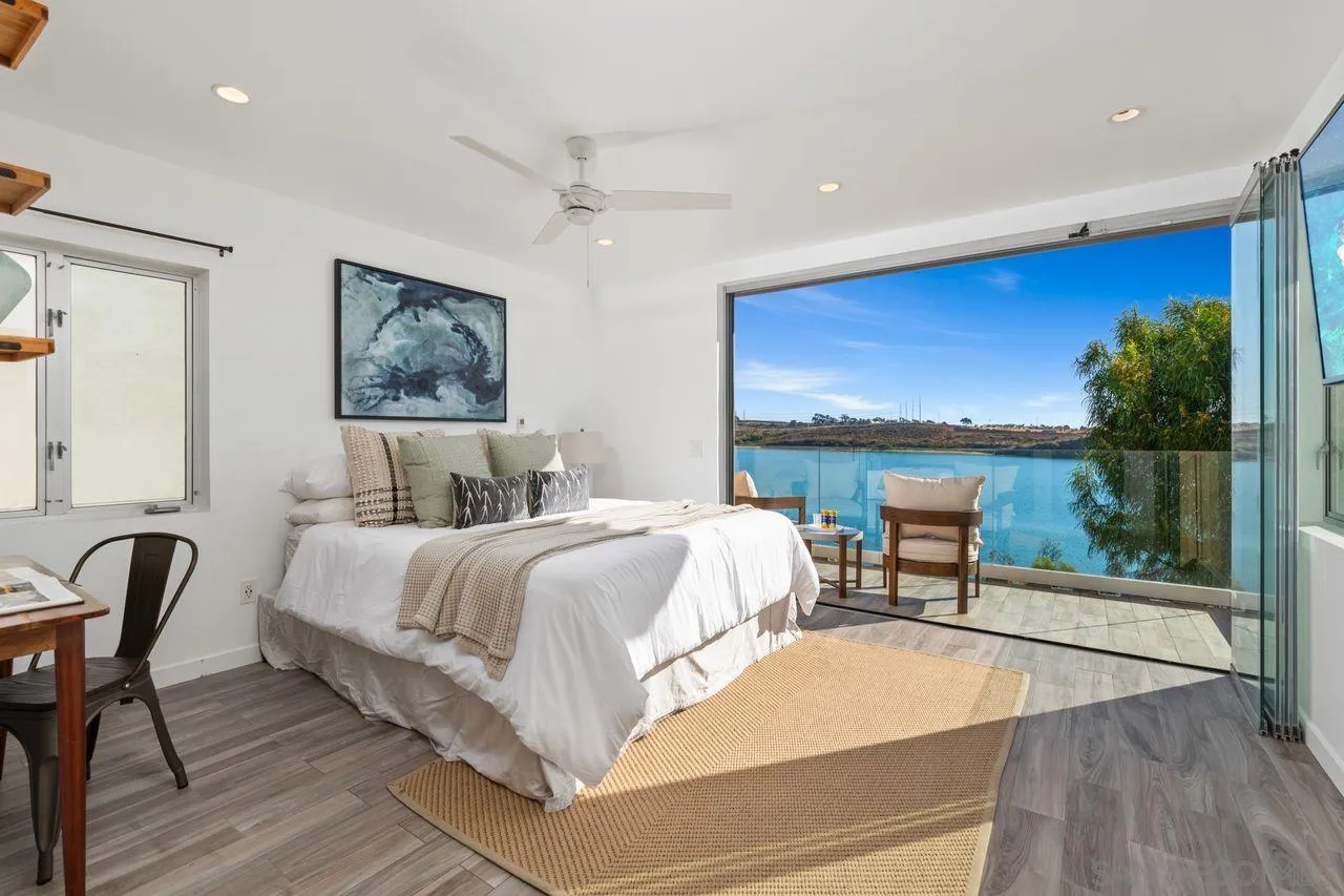 4465 Adams Street Carlsbad, CA 92008 - Photo 42 of 59 a bedroom with a bed a lamp and potted plant with wooden floor